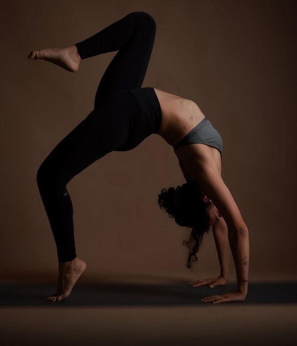 Woman in a calm yoga pose against a dark teal background.